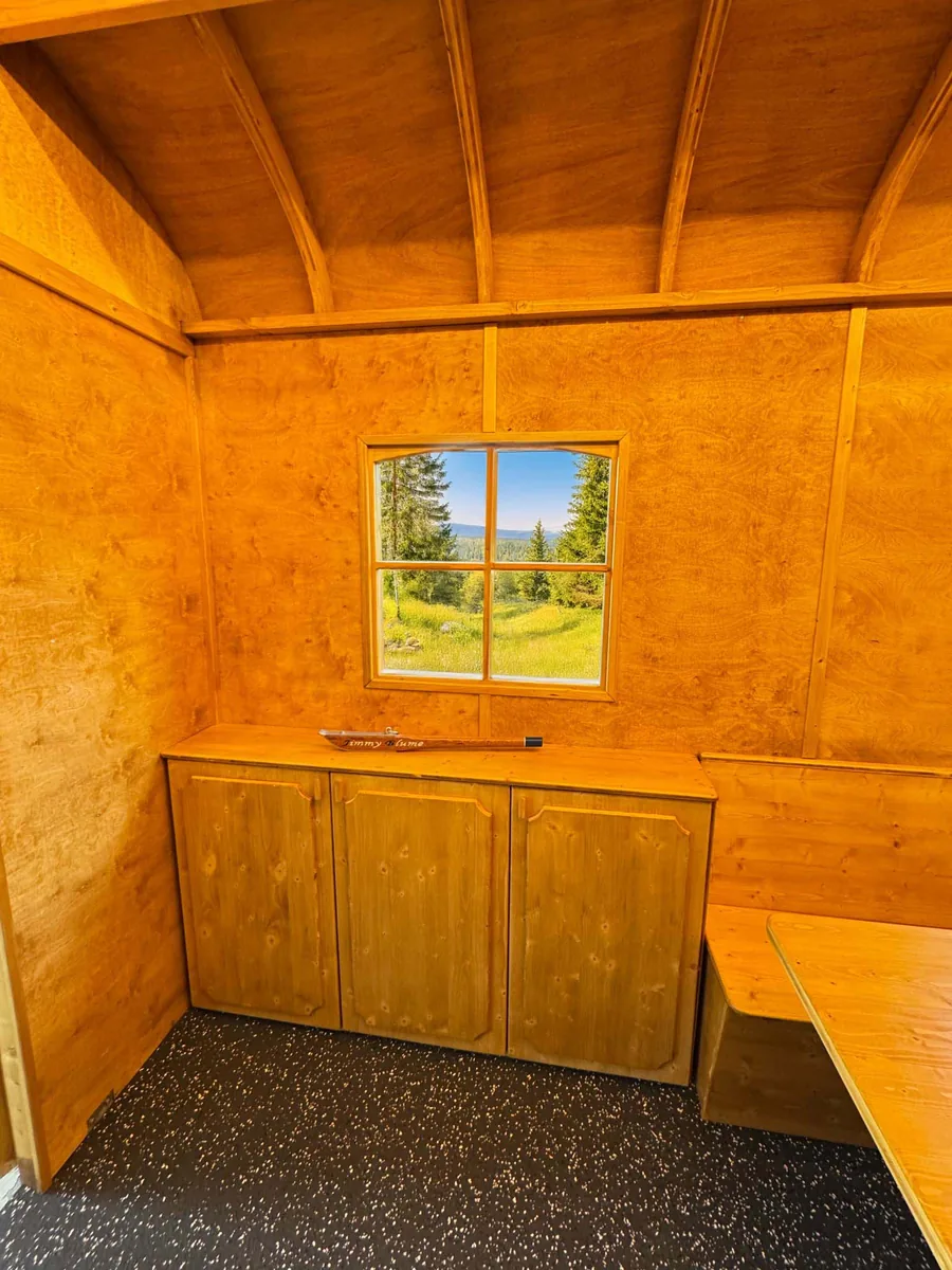 Sitzhütte mit offenem Eingang und Sitzplätzen im Innenraum