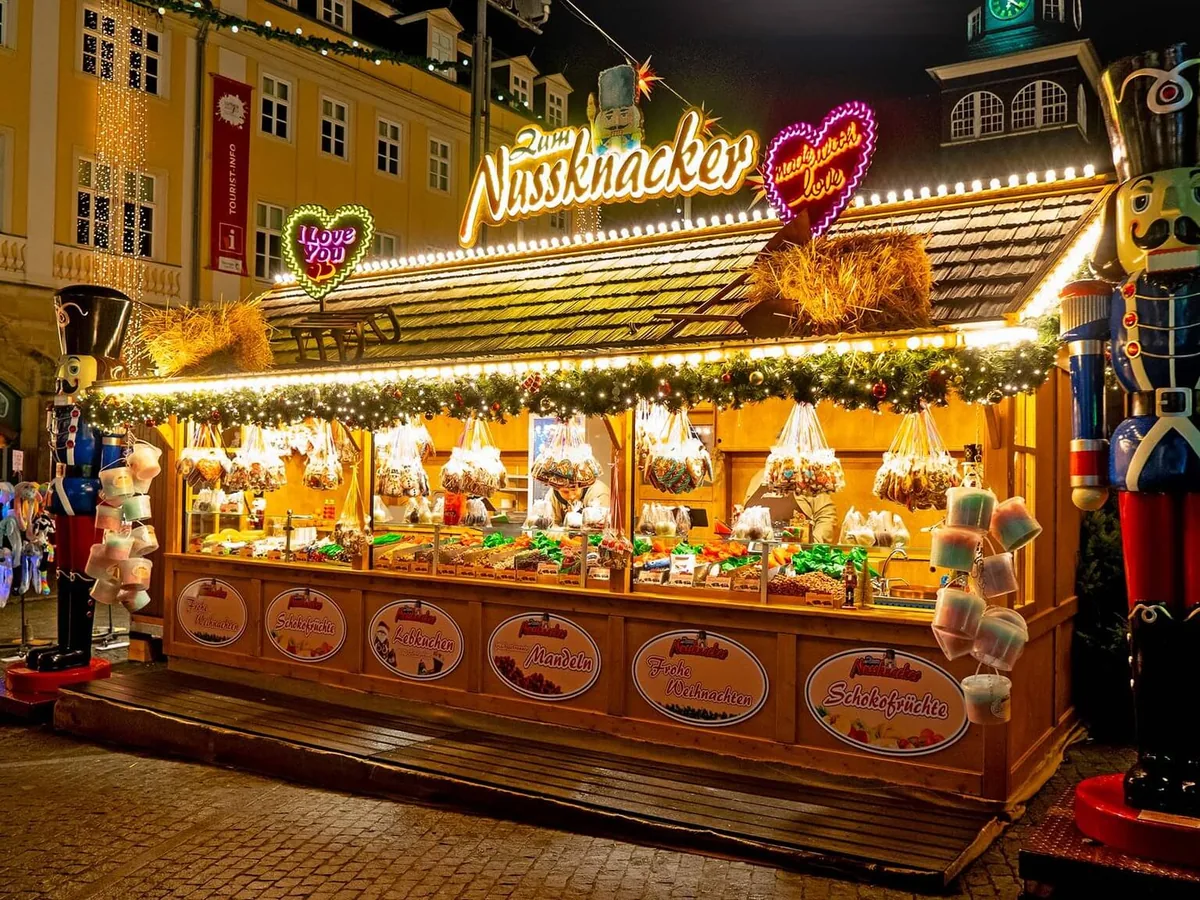 Beleuchtete Verkaufshütten auf einem Weihnachtsmarkt bei Nacht