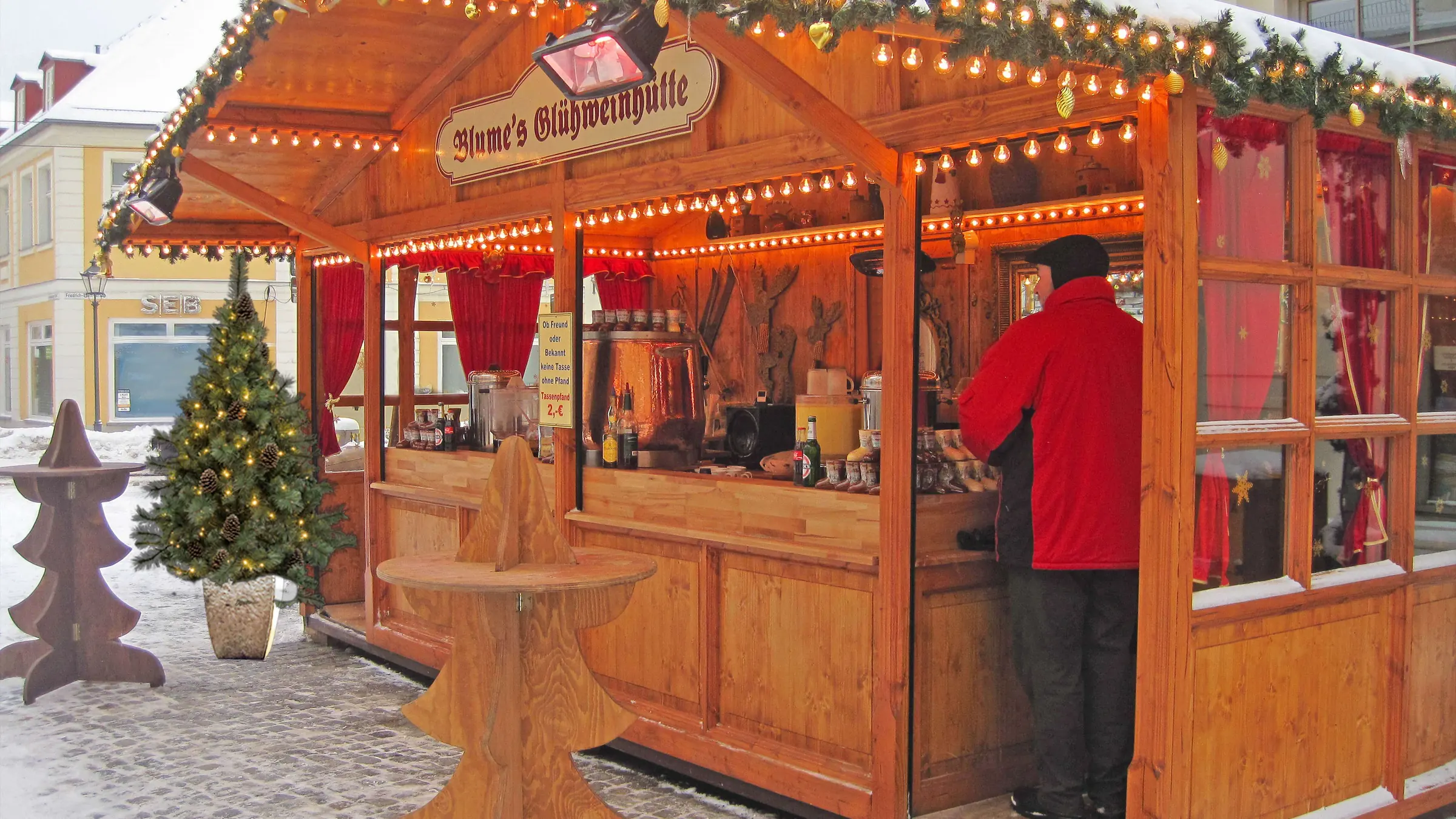 Gemietete Hütte auf dem Weihnachtsmarkt im Betrieb, Glühweinstand mit Personal an der Theke